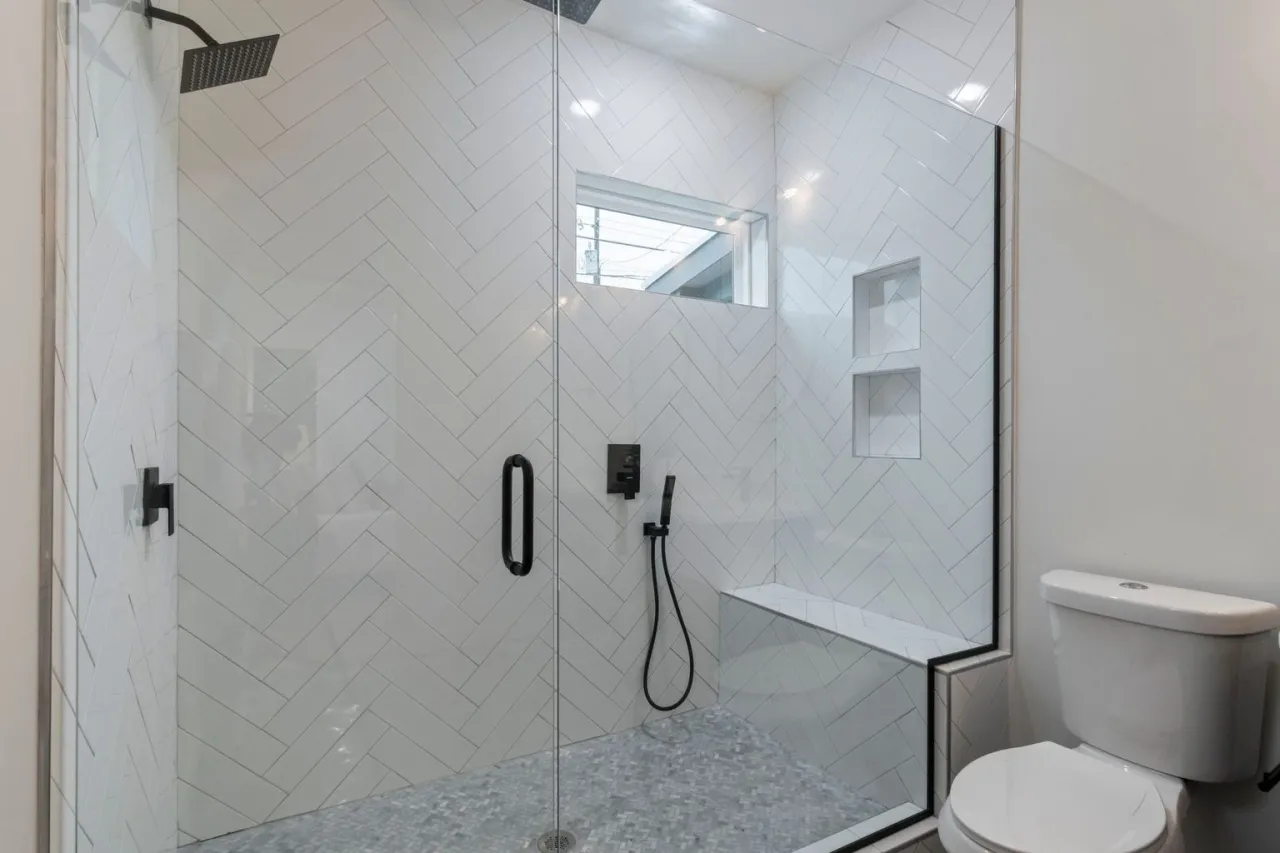 Une douche à l'italienne en carrelage blanc à chevrons, avec niches et banc